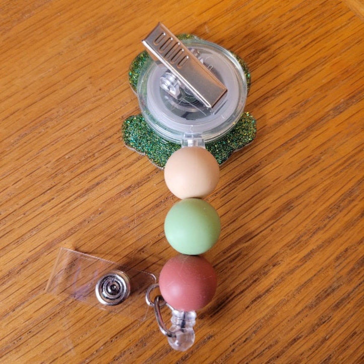 Another new one to our Animal Series... Zen Frog. This cute frog is in a Zen zone in his favorite yoga pose. A dazzling green glitter backing and 3 color-coordinated silicone beads add the perfect finishing touch to this out-of-this-world badge reel.
