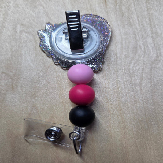 Retractable badge holder with colorful beads on a beige background