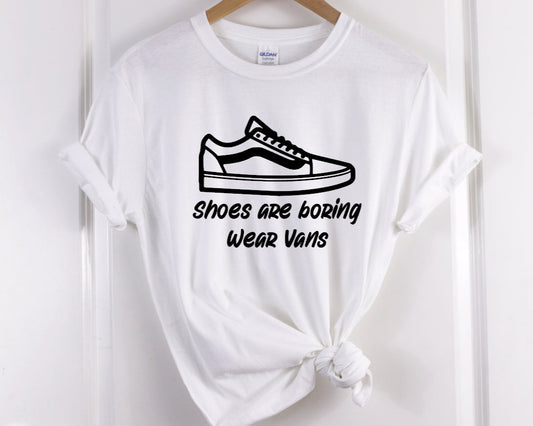 Our T-shirt features a Screen Print Transfer of black lettering with the phrase "Shoes Are Boring Wear Vans." This Unisex adult-sized shirt is made of 5.3 oz. of pre-shrunk 100% cotton.